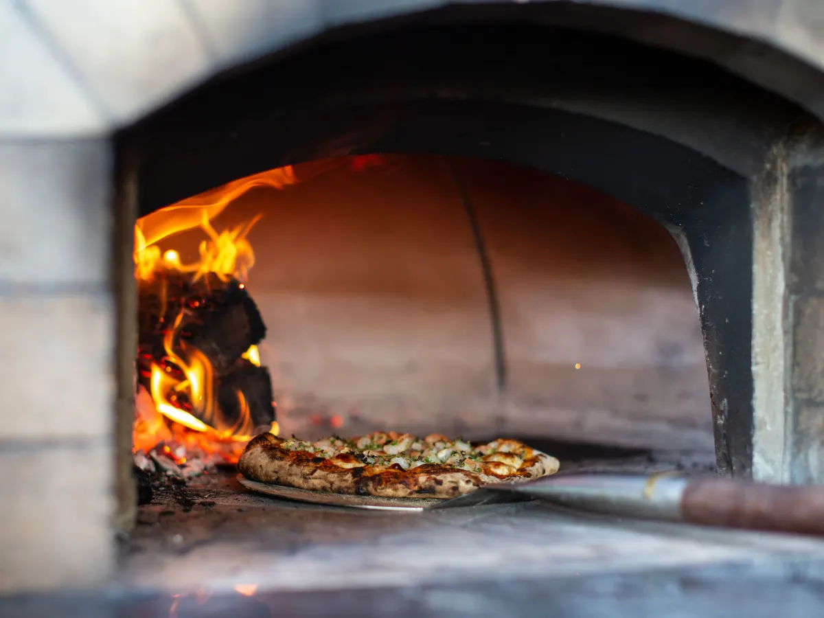 Pizza baking in a wood-fired oven